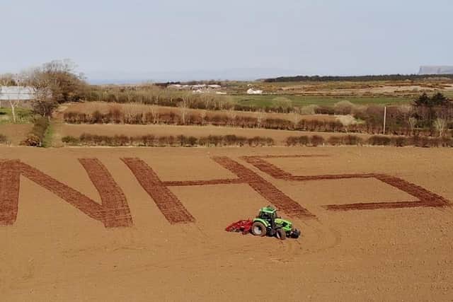 19/04/20.. McAuley Multimedia..Agricultural Machinery sales company Hunter Kane & Son displays a message of support for the NHS, the Ballintoy based company etched the support in a field at Kilmean Farm in Ballintoy