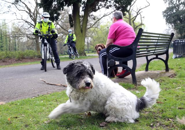 PSNI officers on bicycles talk to members of the public as they patrol Ormeau Park in Belfast on Good Friday