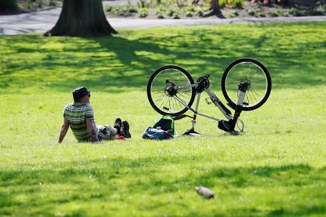 A cyclist takes a breather in the sunshine in Belfast's Botanic Gardens