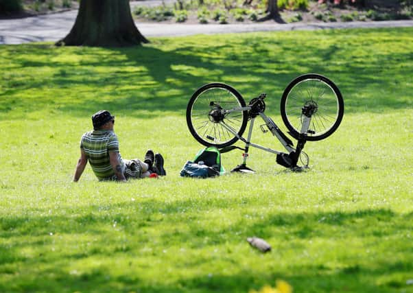 A cyclist takes a breather in the sunshine in Belfast's Botanic Gardens
