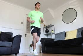 Col Bignell from Comber, Co Down training in his living room as he prepares to run a marathon in his front room which he will run back and forth over 11,000 times
