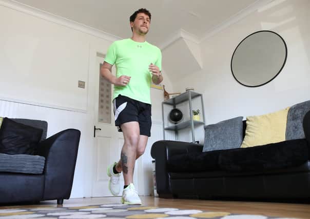 Col Bignell from Comber, Co Down training in his living room as he prepares to run a marathon in his front room which he will run back and forth over 11,000 times