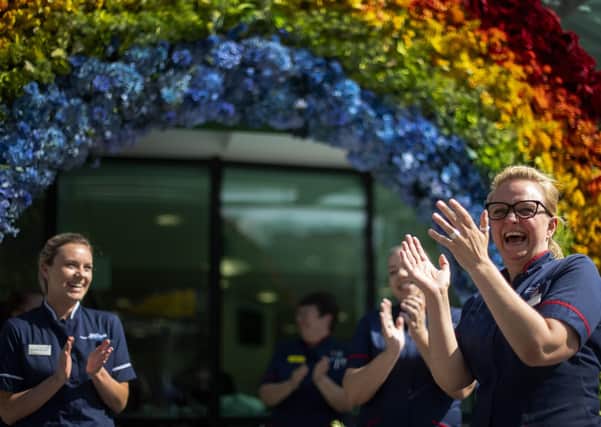 NHS nurses help to unveil a rainbow floral display outside the University College Hospital at Euston Road, in London to thank the public for their support during the ongoing coronavirus pandemic. PA Photo: Thursday April 23, 2020