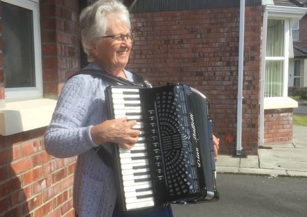 Mrs Mabel Shaw, of Connor, plays her accordion outside her house during the applause for the NHS staff on Thursday April 16 2020