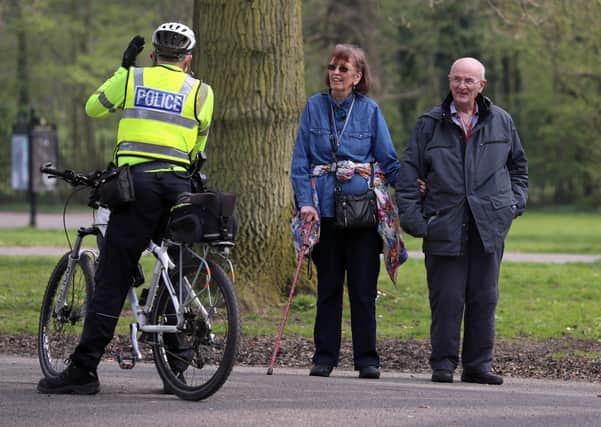 A PSNI officer on a bicycle talks to members of the public as they patrol Ormeau Park in Belfast. 
PICTURE BY STEPHEN DAVISON