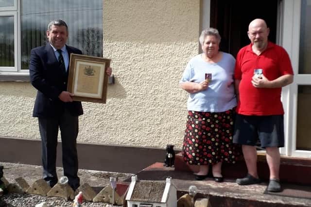 Iain Lendrum of Fivemiletown RBL with Helen and William Bradshaw and Helen's father's WWII Memorial Scroll