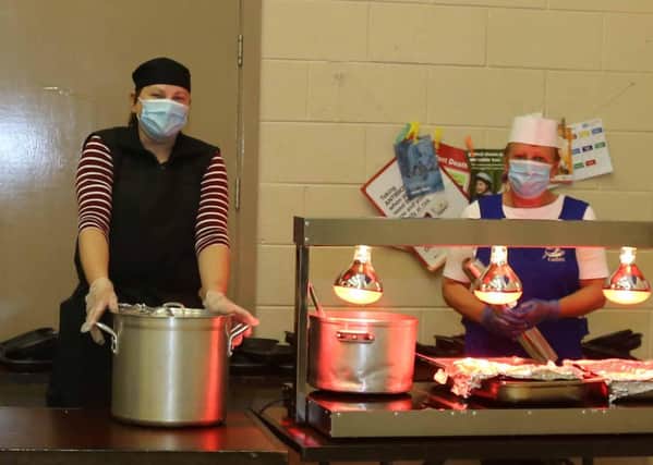 Barbara Pinkerton and Karen Spratt preparing hot meals to be delivered by Orange volunteers