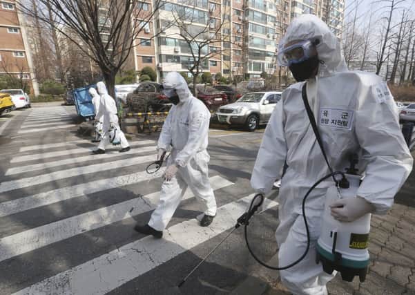 South Korean army soldiers spray disinfectant as a precaution against coronavirus on a street in Seoul last month. "Thankfully Northern Ireland is more like South Korean in infection levels," says Melanie Houston (AP Photo/Ahn Young-joon)