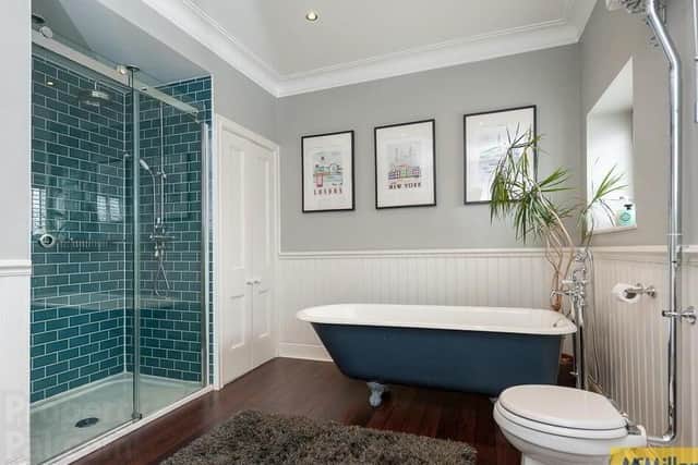 Luxury bathroom with white suite and roll top bath