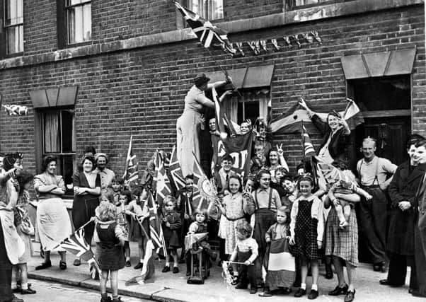 Men, women and children celebrating 'Victory in Europe Day' in the street in an unidentified city in the UK on May 8 1945. Such celebrations took place across the nation, including Northern Ireland. Photo: PA Wire
