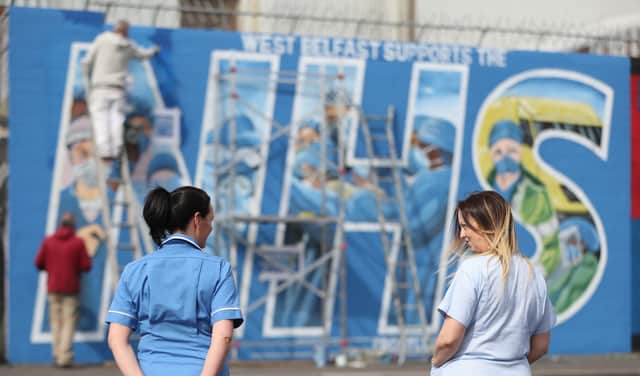 Nurses watch as a mural is painted in recognition of the NHS on the Falls Road in Belfast