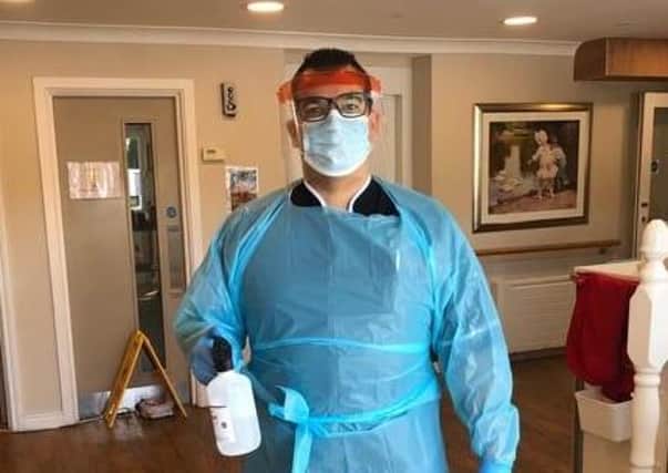 Beechvale Nursing Home deputy manager Felipe Ferreira dons his PPE while cleaning