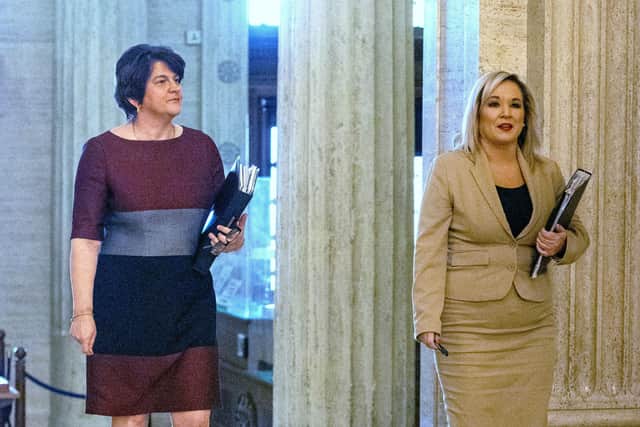 First minister Arlene Foster (left) and Deputy First Minister Michelle O'Neill walk together as they arrive at Stormont prior to announcing to the Northern Ireland Assembly, the Executive's approach to coronavirus decision-making