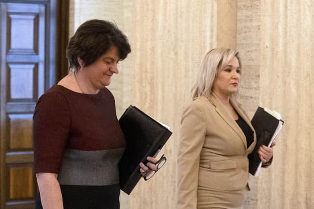 First minister Arlene Foster (left) and Deputy First Minister Michelle O'Neill walk together as they arrive at Stormont prior to announcing to the Northern Ireland Assembly, the Executive's approach to coronavirus decision-making