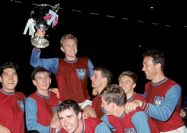 West Ham United celebrate with the European Cup Winners' Cup after their 2-0 win in 1965: (back row, l-r) Alan Sealey, Martin Peters, Bobby Moore (with cup), Geoff Hurst, John Sissons and Ken Brown.