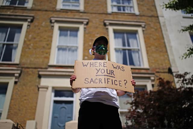 A protester holds a sign up outside the home of prime minister Boris Johnson's senior aide Dominic Cummings in north London, after allegations he breached lockdown restrictions. Photo: Aaron Chown/PA Wire