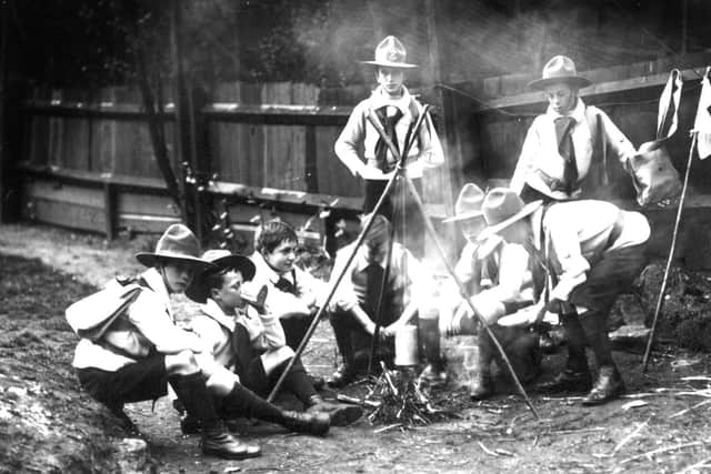 A file picture dated 1910 of a group of Boy Scouts, as they appeared then, sitting around a camp fire.