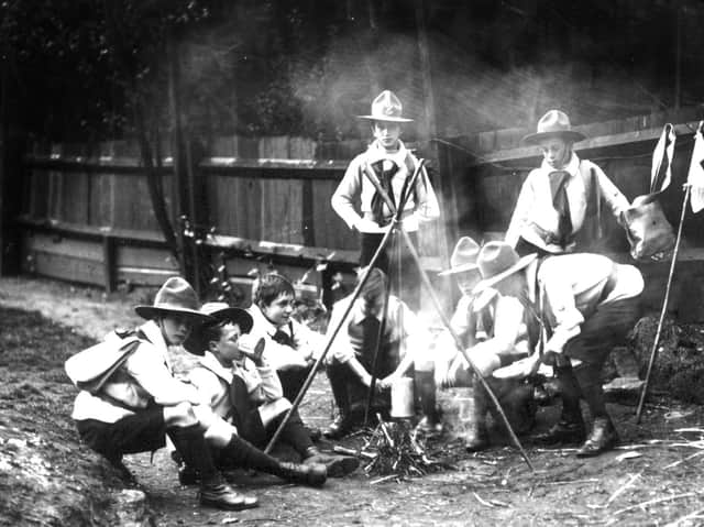 A file picture dated 1910 of a group of Boy Scouts, as they appeared then, sitting around a camp fire.
