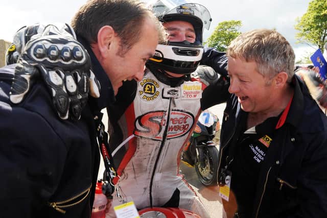 A jubilant Michael Dunlop celebrates his first Isle of Man TT win with sponsors Gary Ryan (left) and Martin Marlow.