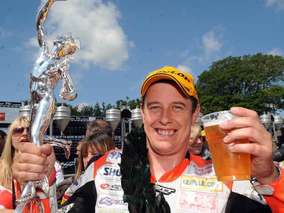 John McGuinness celebrates his 14th Isle of Man TT victory with a pint after winning the 2008 Senior race.