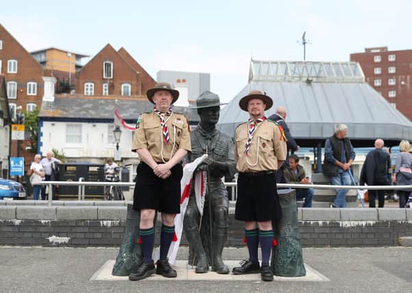 Rover Scouts Chris Arthur (left) and Matthew Trott pose for a photograph in front of a statue of Robert Baden-Powell on Poole Quay in Dorset on Thursday amid an outcry over plans to remove it amid concerns about his actions while in the military and 'Nazi sympathies'. Photo: Andrew Matthews/PA Wire