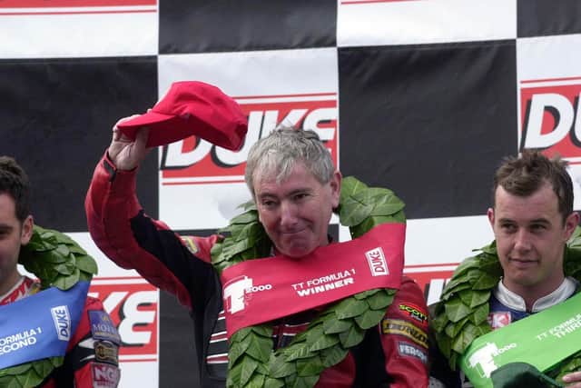 Joey Dunlop acknowledges the fans after winning the 2000 Formula One race at the Isle of Man TT from runner-up Michael Rutter (left) and John McGuinness.