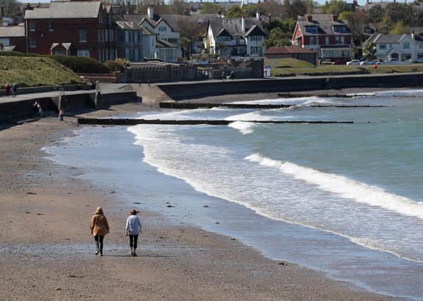 Walkers on Bangor beach enjoying the recent extended spell of good weather