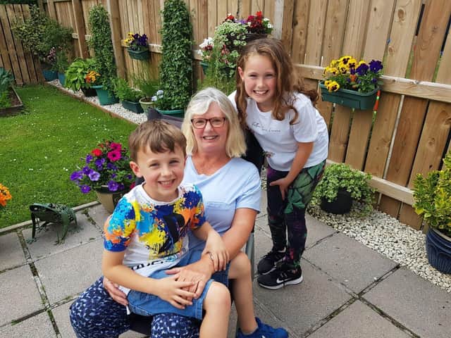Grandmother Susan Hamilton reunited with grandchildren Robbie Benson (6) and Victoria Benson (9).