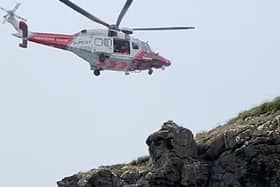 The coastguard helicopter lifted one youth from the water to the clifftop. Photo: McAuley Multimedia