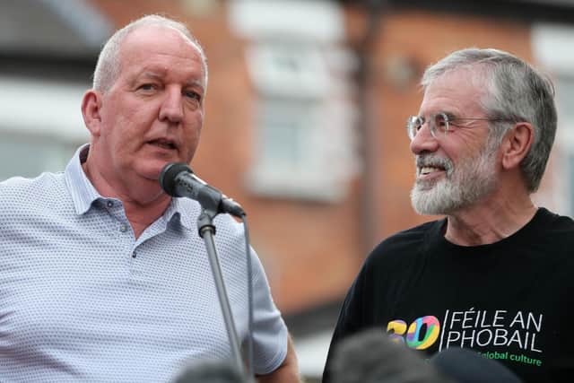 Bobby Storey (left) and Gerry Adams address a rally beside the old Andersonstown police station, Belfast, following attacks on their homes in 2018