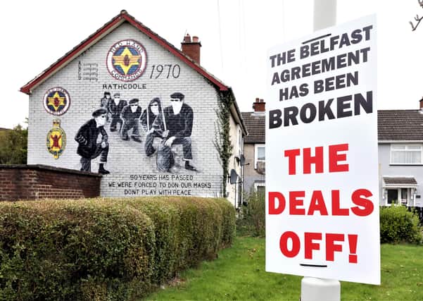 PACEMAKER, BELFAST, 22/3/2021: A sign claiming the Belfast (Good Friday) Agreement has been broken by the Northern Ireland protocol in Britain's Brexit deal has been erected beside a mural of masked members of the loyalist paramilitary group, the Red Hand Commandos in the Rathcoole estate, Newtownabbey, Co Antrim. 
The legend on the mural reads 'Don't play with peace.'
PICTURE BY STEPHEN DAVISON