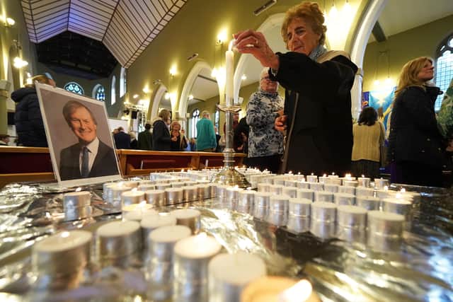 People light candles during a vigil at St Michael & All Angels church in Leigh-on-Sea in Essex for Conservative MP Sir David Amess who died after he was stabbed several times at a constituency surgery on Friday