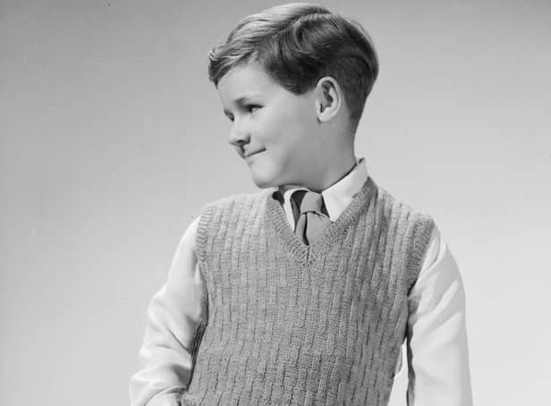 This little  boy looks happy in his jaunty woollen tank top, but is he really?