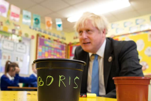 Prime Minister Boris Johnson joins schoolchildren as they plant seeds for trees during a visit to Crumlin Intergrated primary school in Co Antrim.