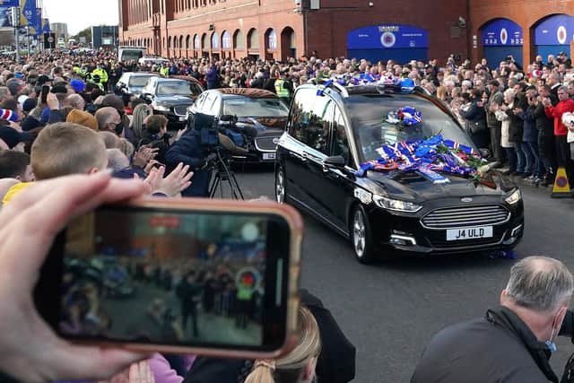 Crowds take photographs as the funeral procession passes Ibrox Stadium, home of Rangers FC. Picture date: Wednesday November 3, 2021.