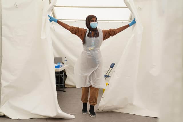 A NHS worker looks for patients at a Covid-19 pop-up vaccination centre. Scientists are hopeful that the booster jabs rollout and immunity from the summertime spread of the more transmissible Delta coronavirus variant should help Britain escape the surge in infections seen in parts of Europe