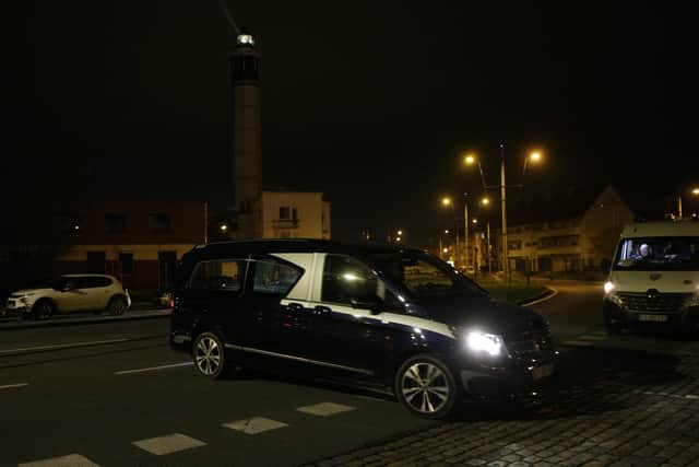 A hearse enters the port of Calais, northern France, Wednesday, Nov. 24, 2021. At least 31 migrants bound for Britain died when their boat sank in the English Channel. (AP Photo/Michel Spingler)