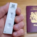 a negative lateral flow Covid-19 test in front of a passport for the United Kingdom of Great Britain and Northern Ireland