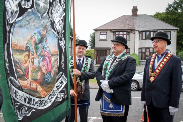 Sir Knight Eddie Graham (centre) who hand painted the banner, with Sovereign Grand Master Rev William Anderson (right)