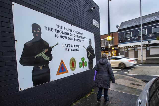 A woman walks past a banner in support of Ulster loyalist paramilitary group the Ulster Volunteer Force (UVF) east Belfast Battalion. Picture date: Tuesday November 30 2021.
