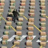 A police officer walks among seized packages of drugs in Cali, Colombia. The people of Colombia have suffered much violence over drugs trafficking and in the decades-long conflict with the outlawed Revolutionary Armed Forces of Colombia (FARC)