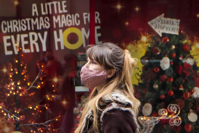 A woman walks past a Christmas display in a shop window