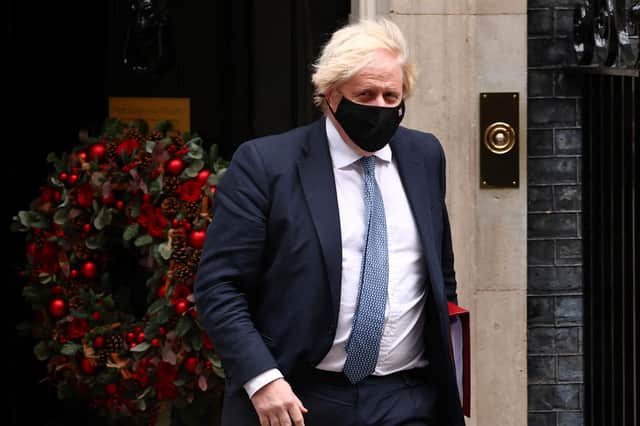 Britain's Prime Minister Boris Johnson, wearing a face covering to stop the spread of coronavirus, leaves from 10 Downing Street in central London on December 8, 2021, to take part in the weekly session of Prime Minister Questions (PMQs) at the House of Commons. - British Prime Minister Boris Johnson faced intense pressure Wednesday after a video emerged of his senior aides joking about holding a Christmas party at Downing Street last year when social gatherings were banned under Covid-19 rules. (Photo by Adrian DENNIS / AFP) (Photo by ADRIAN DENNIS/AFP via Getty Images)