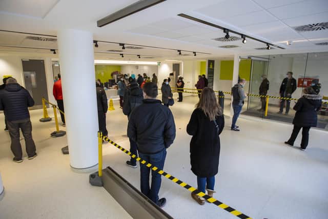 People queuing in reception at the COVID-19 vaccination centre at Dundonald Hospital in Belfast, Northern Ireland. PA Photo. Picture date: Tuesday December 14 2021. See PA story ULSTER Coronavirus. Photo credit should read: Liam McBurney/PA Wire