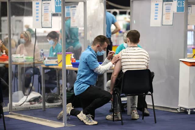 People get vaccinations at a COVID-19 booster vaccination centre at the Titanic Exhibition Centre in Belfast