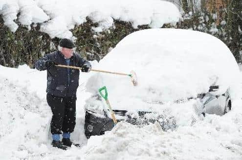 A man clears snow off his car in the 'big freeze' in 2010.
