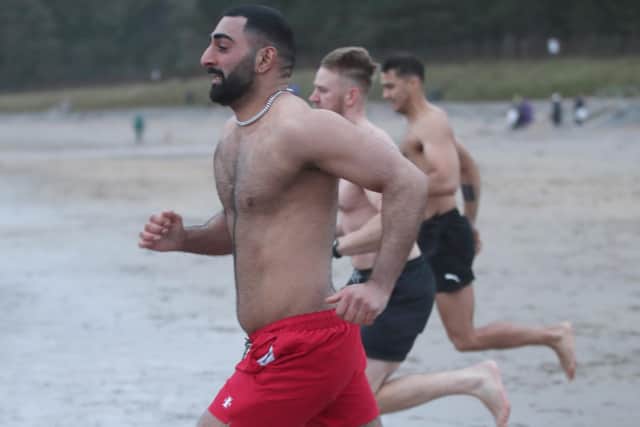 (L-R) Sev.G, Daniel Howes and Tiga Dengie keep warm by running to the water at Helen's Bay for their annual Christmas Day plunge.

Photograph by Declan Roughan / Press Eye