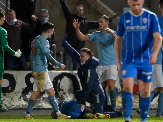 Coleraine player Conor McKendry receives treatment as Ballymena United celebrate their late winner
