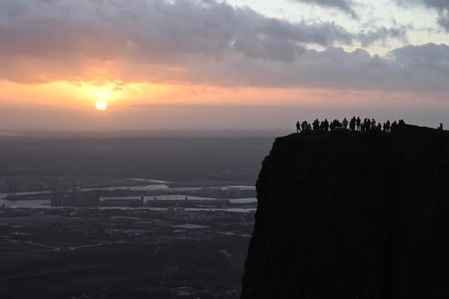 See the people silhouetted on the top of Cavehill, as they watch as the sun rising over Belfast just after 846am on New Year's morning. Picture: Michael Cooper