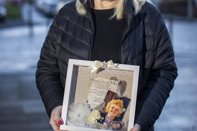 Margaret Deery holds an image of her mother Peggy Deery